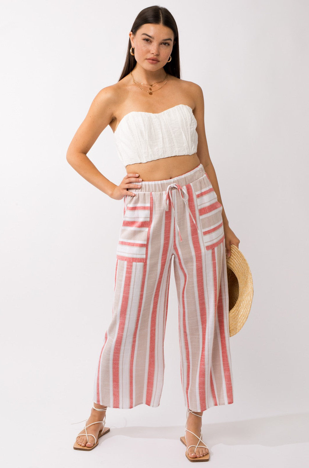 Brunette female model wearing linen striped pants and cotton top