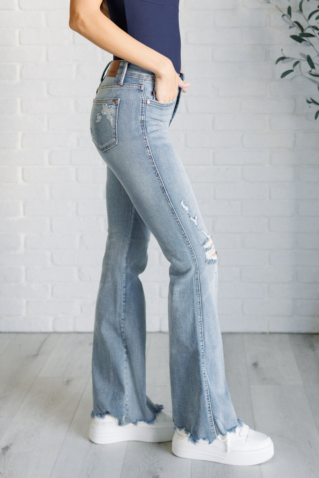 Caroline Mid Rise Control Top Distressed Flare Jeans side view on Casey