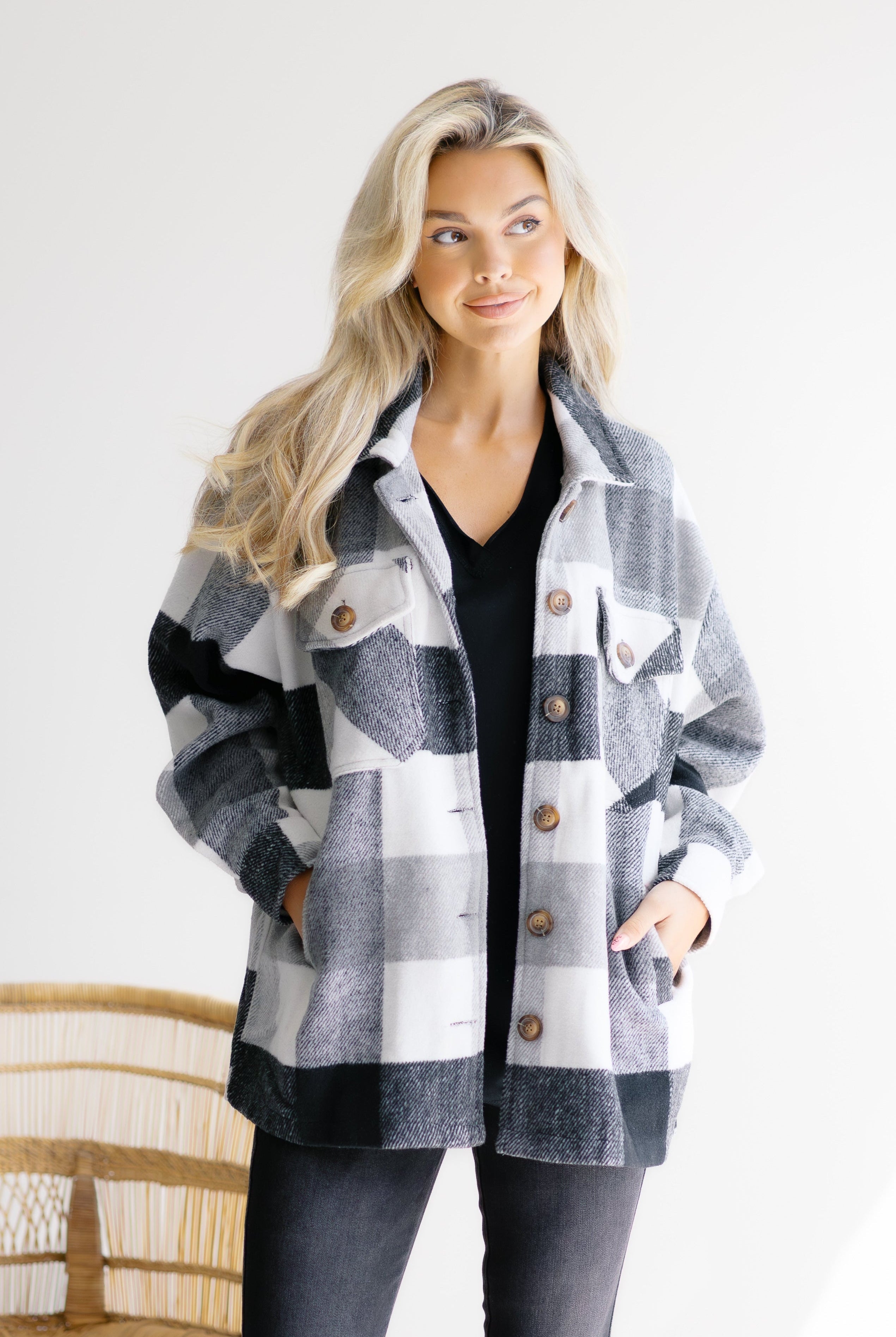 Woman wearing a plaid jacket with a white background