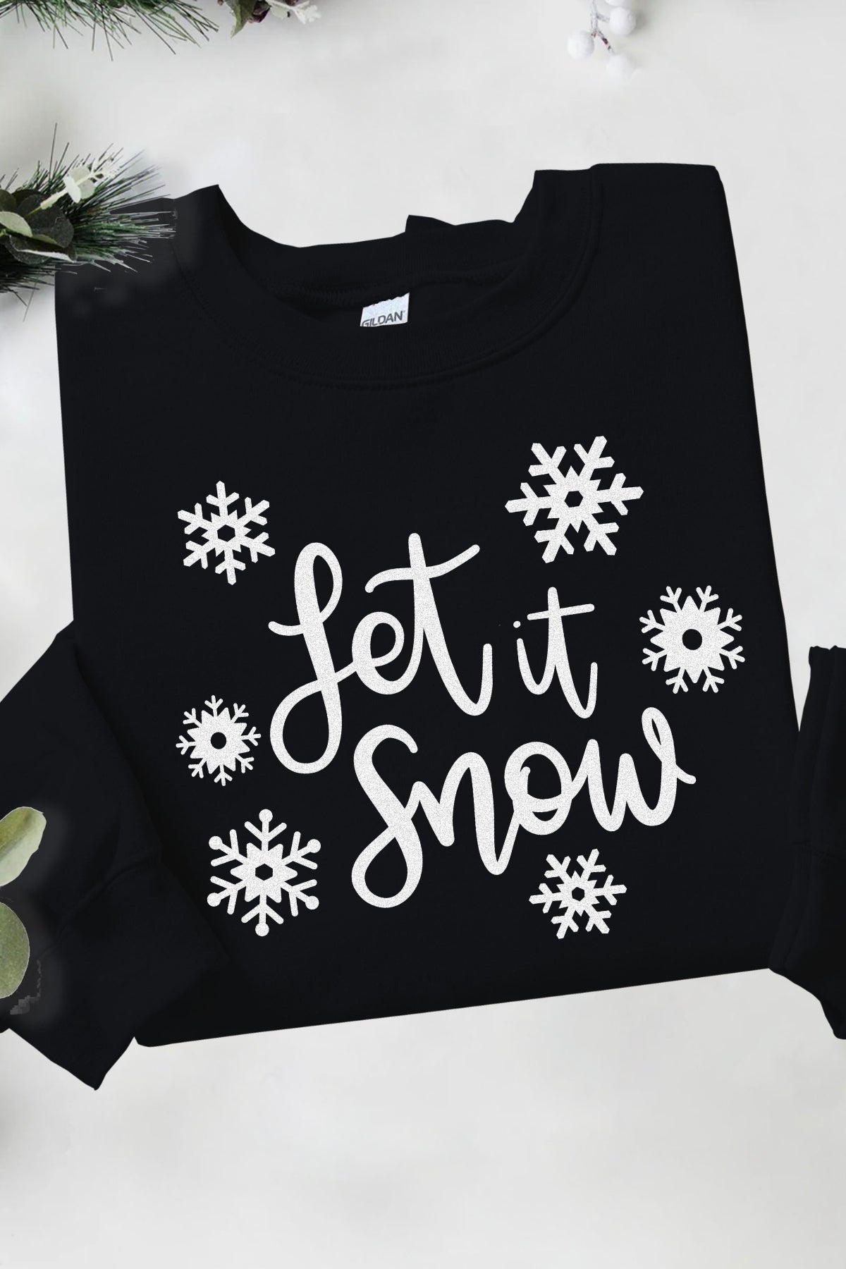 Let it Snow on black Gildan pullover crewneck sweatshirt with snowflakes