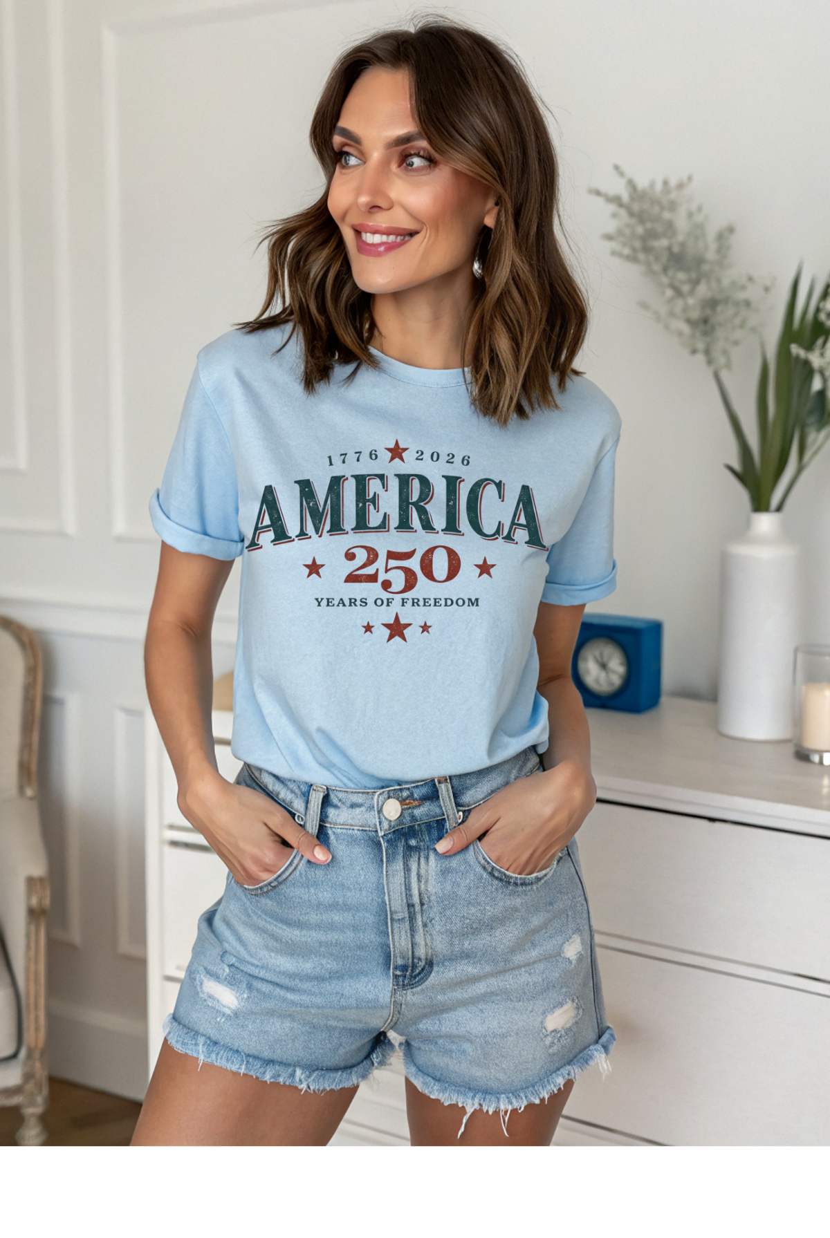 Woman wearing a light blue t-shirt with 'America 250' text in a home setting.