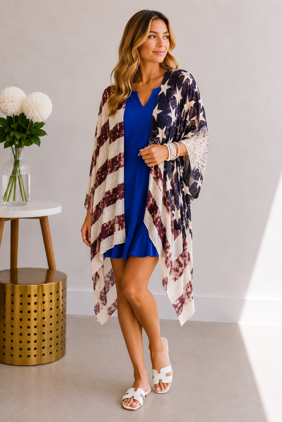 Woman wearing a blue dress with an American flag patterned cover-up in a room.