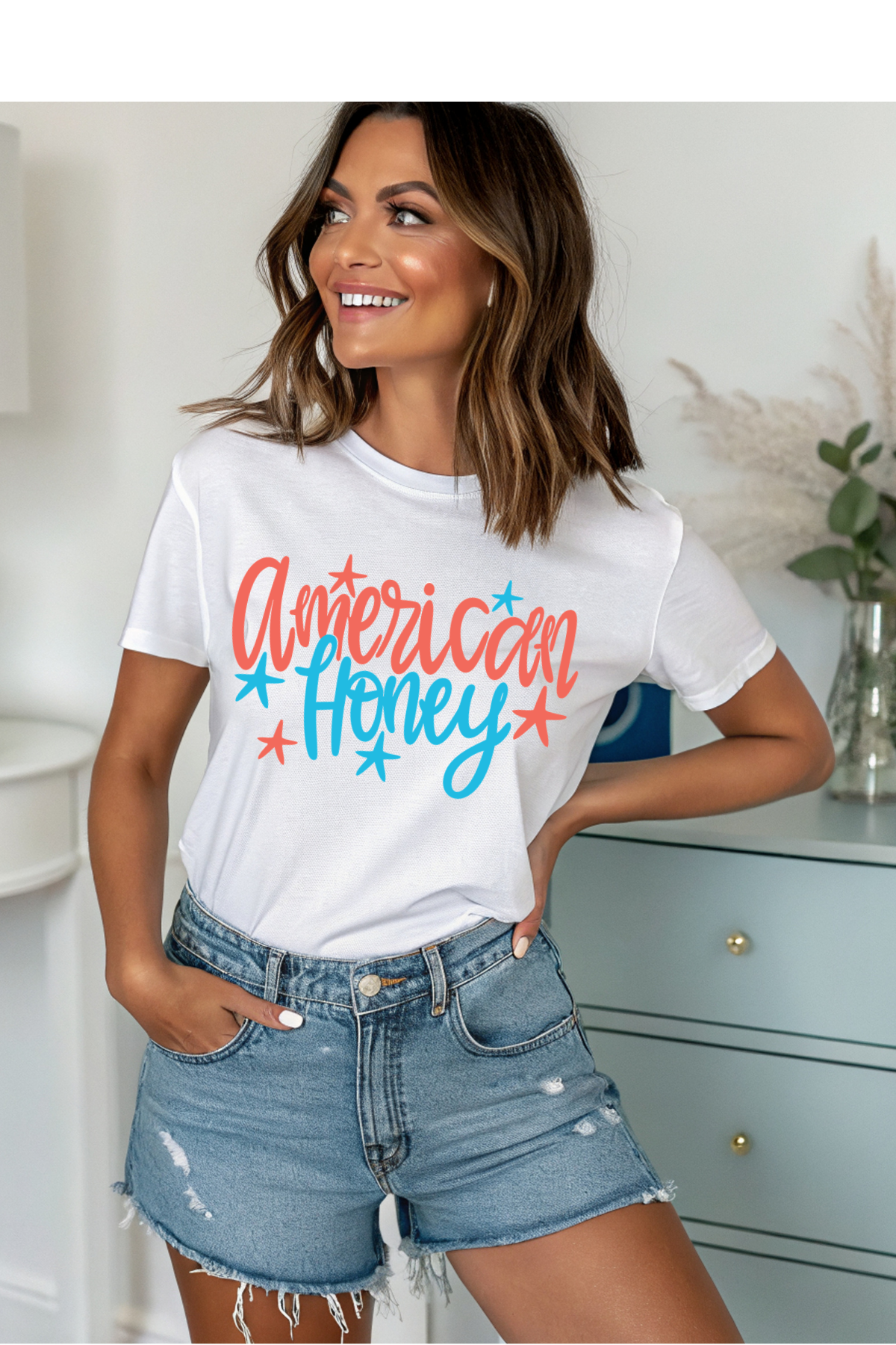 Woman wearing a white t-shirt with 'American Honey' text, standing in a room.