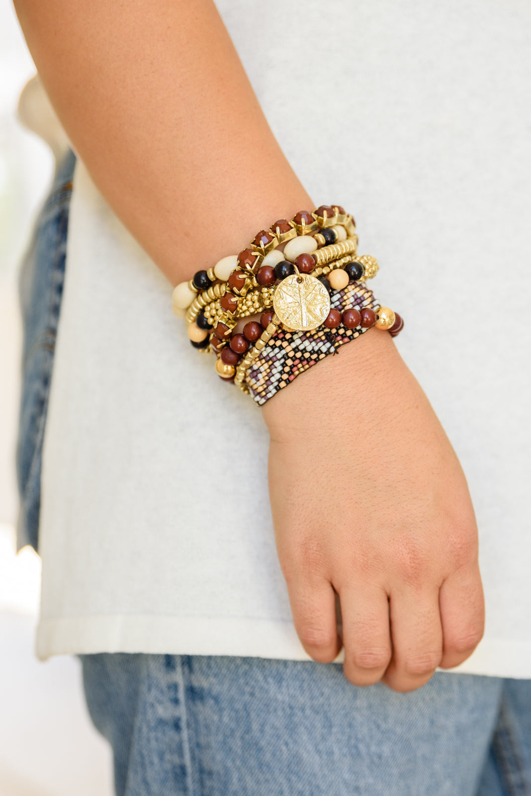 Set of braceltes with beeds in rust, black, natural, and gold tones