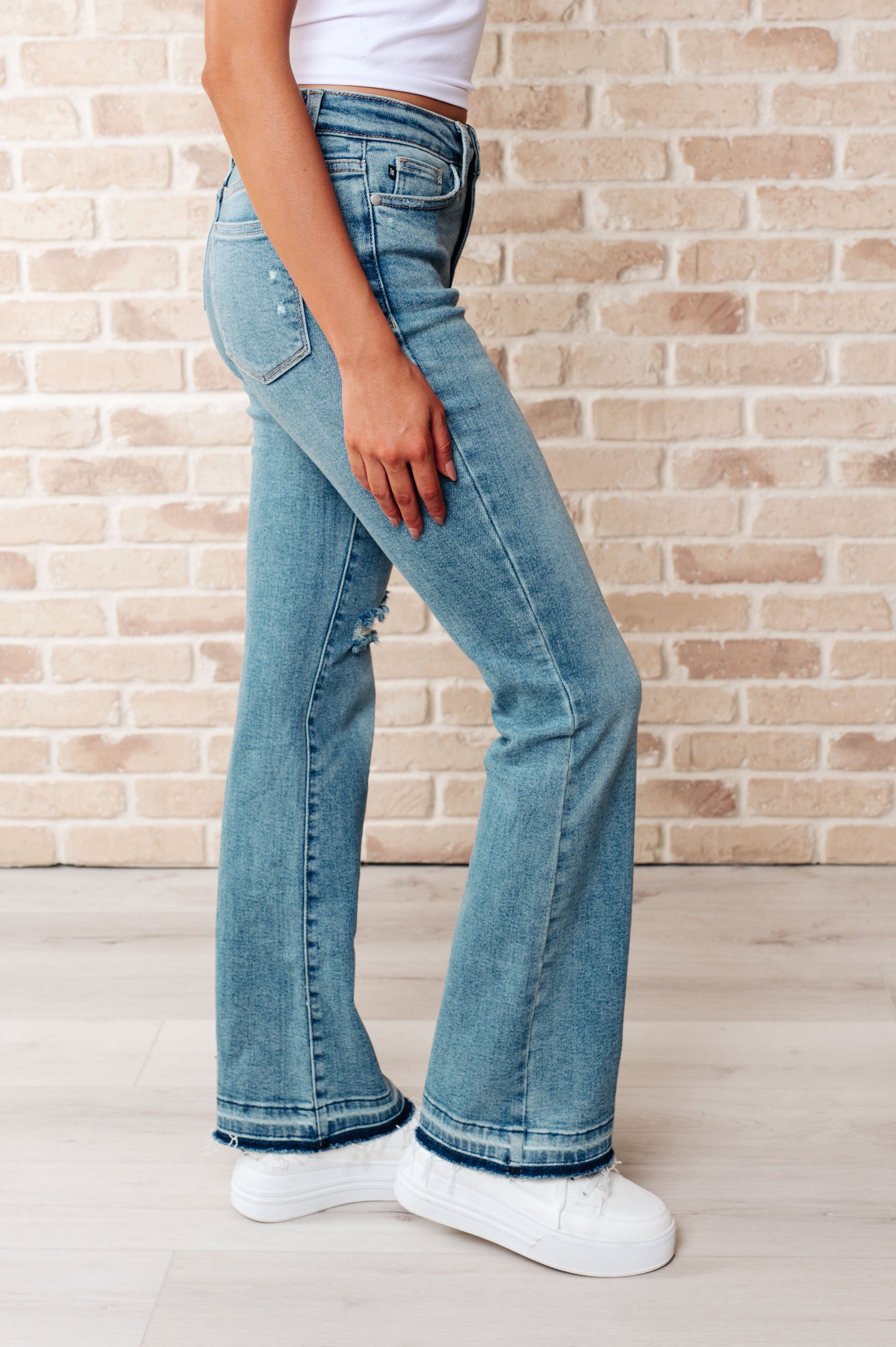 Judy Blue Mid Rise Distressed Released Hem Bootcut Jeans side view - Isla
