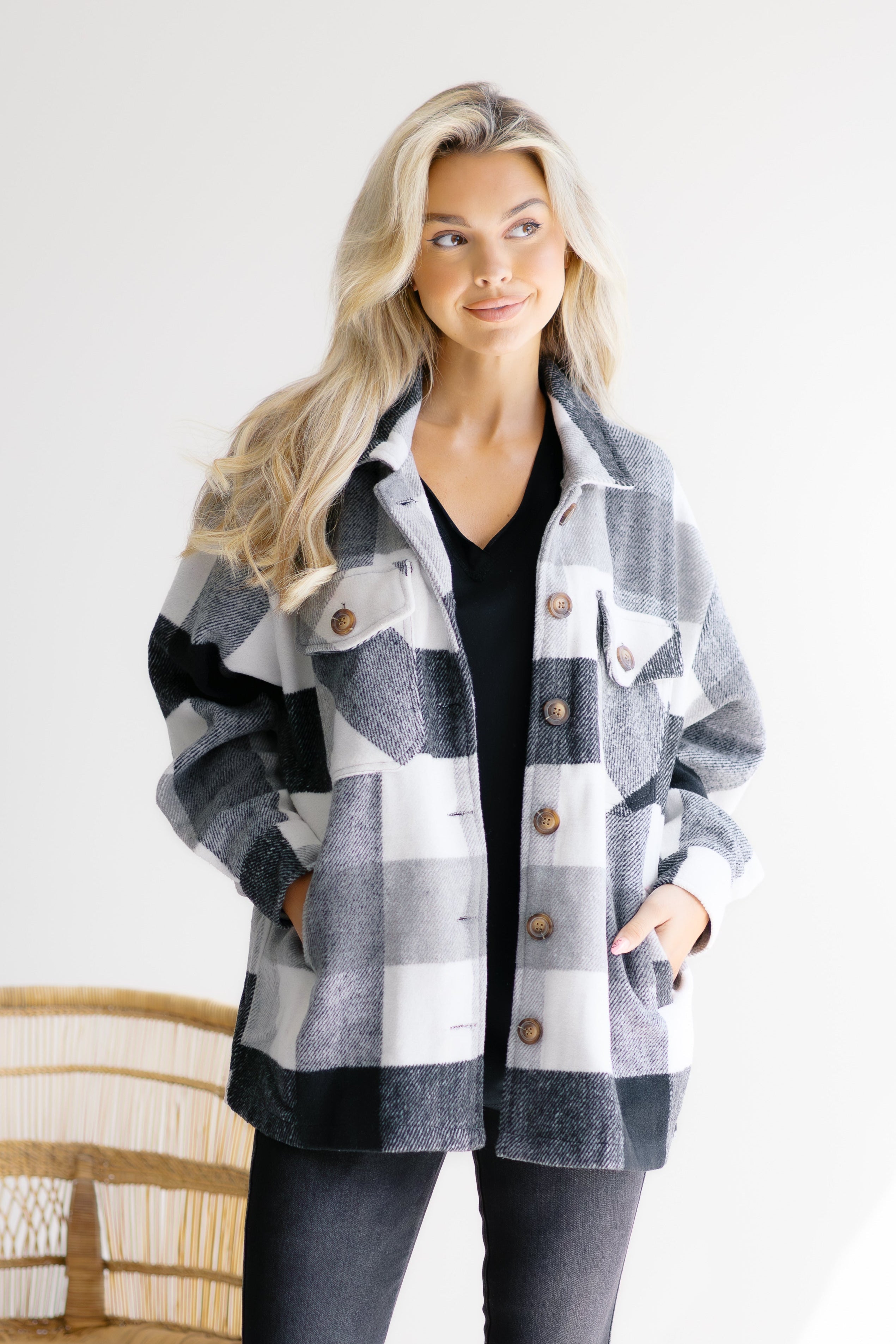 Woman wearing a plaid jacket with a white background