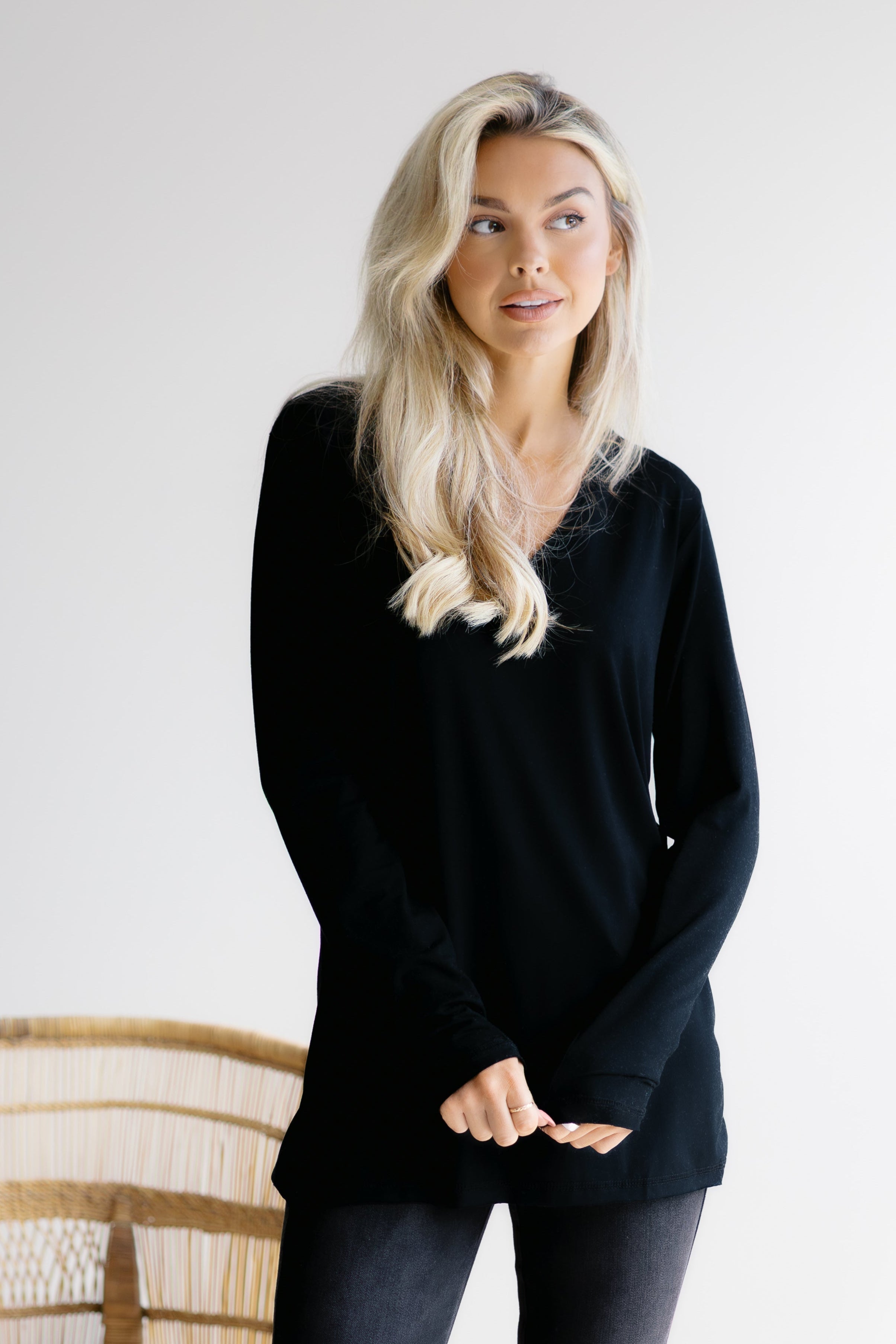 Woman wearing a black long-sleeve top against a white background