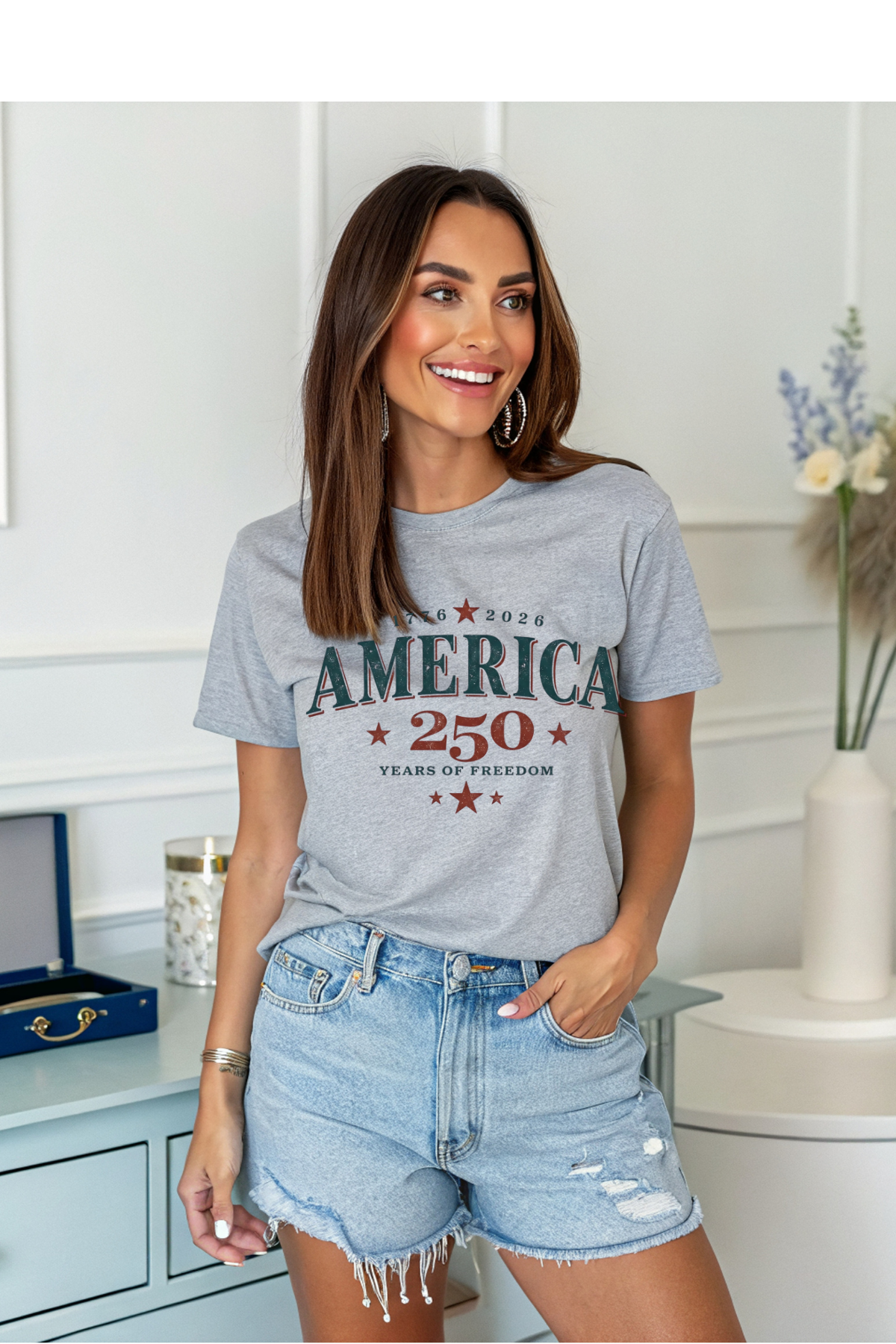 Woman wearing a gray t-shirt with 'America 250' text in a room.