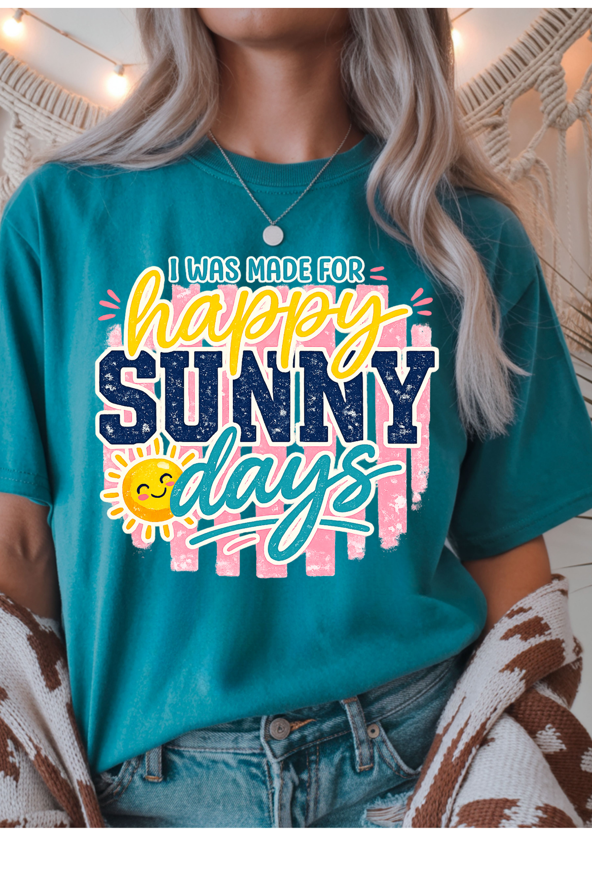 Person wearing a teal t-shirt with 'happy sunny days' text and sun graphic.