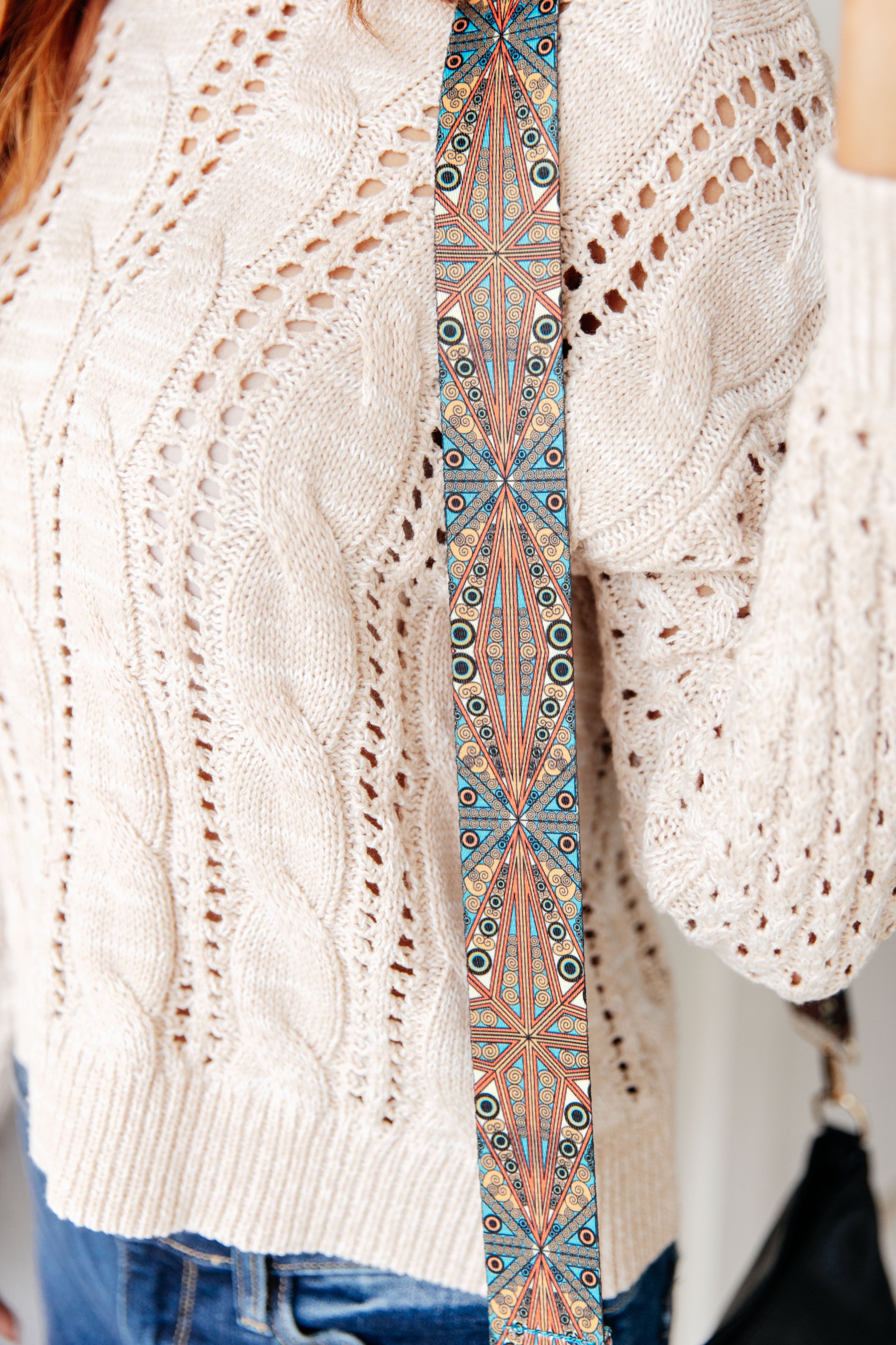 Close up detail of purse strap design in blue, orangish red, and gold colors